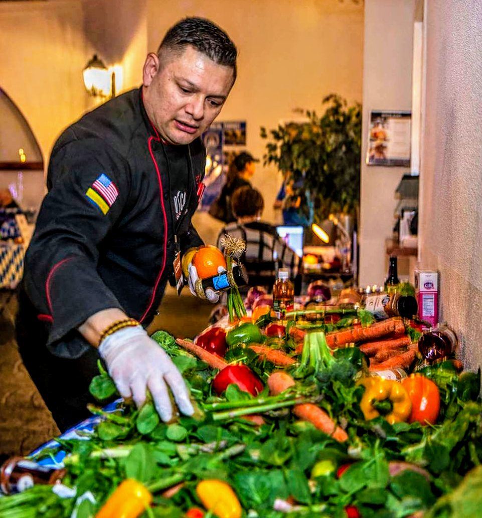 Chef Oscar Sanchez arranging a large fresh produce and crudit&eacute; display