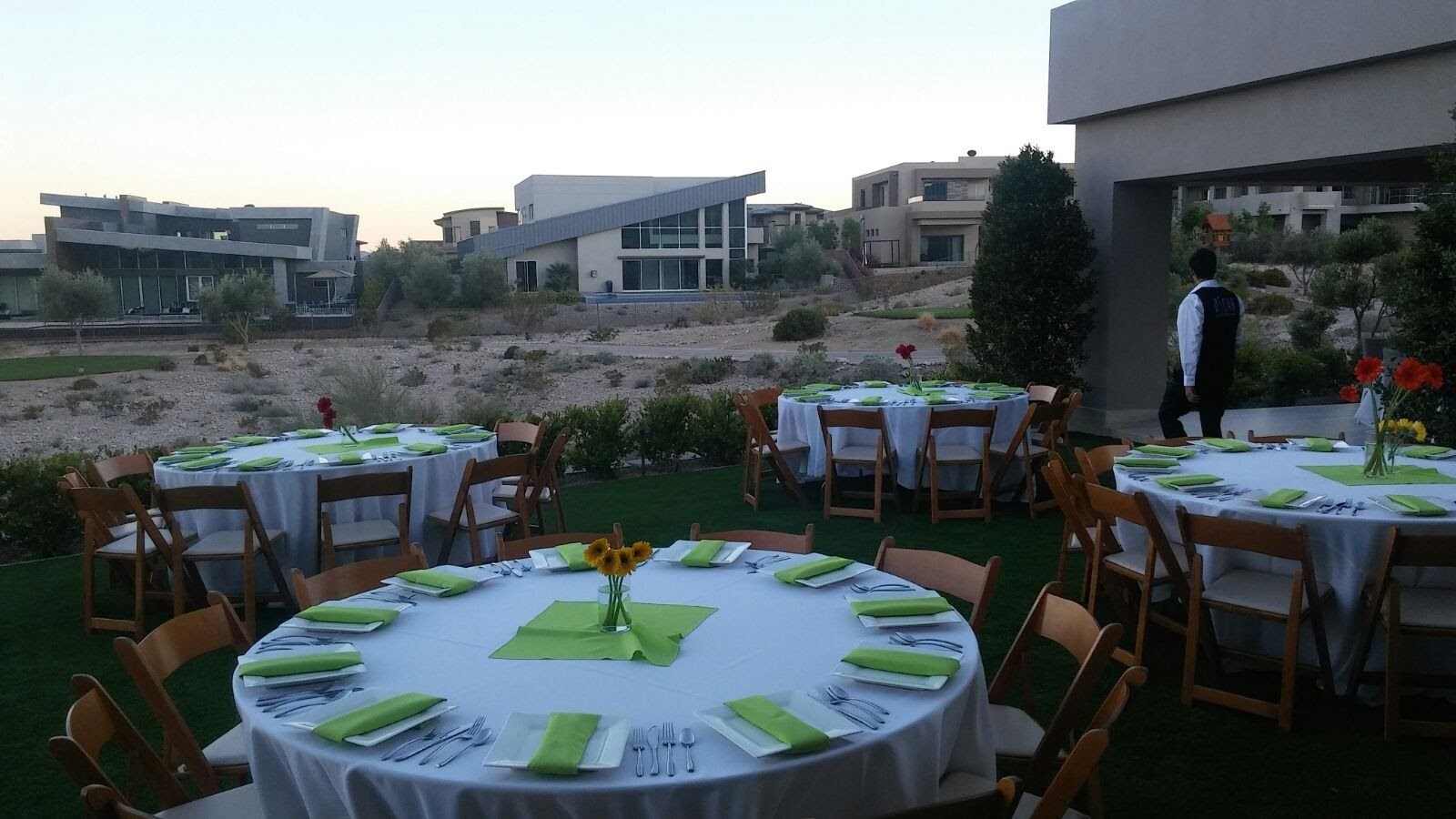 Outdoor estate dinner service set for guests at dusk