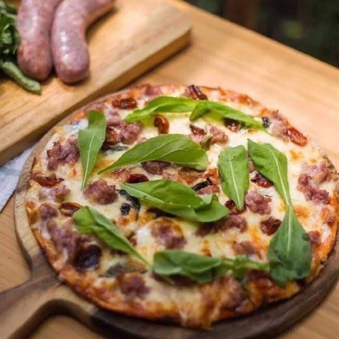 Pizza with basil and cured meat